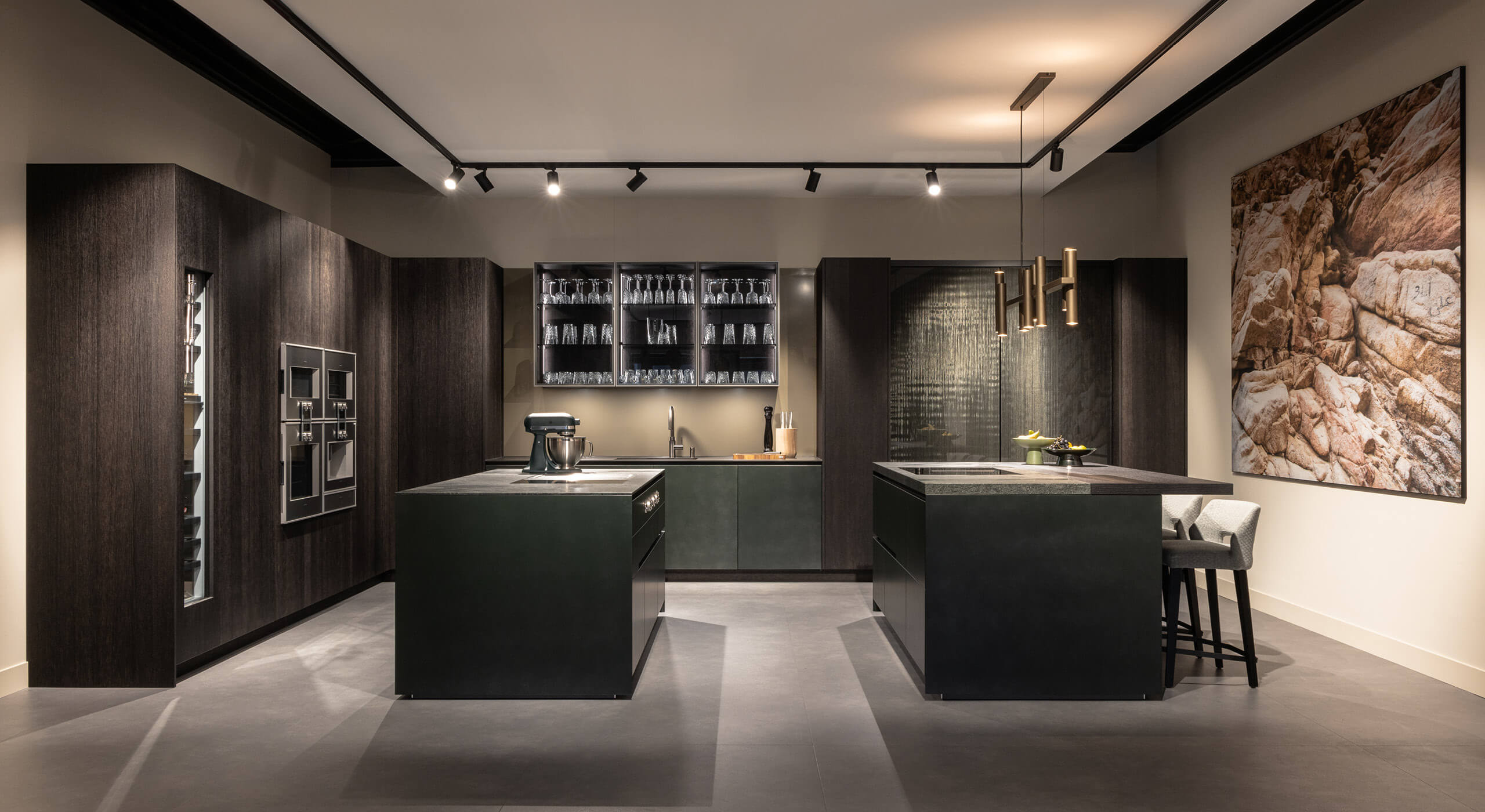 Gaggenau keuken op maat met kookeiland en houtlook zwarte fronten en groene keuken details met glazen kasten